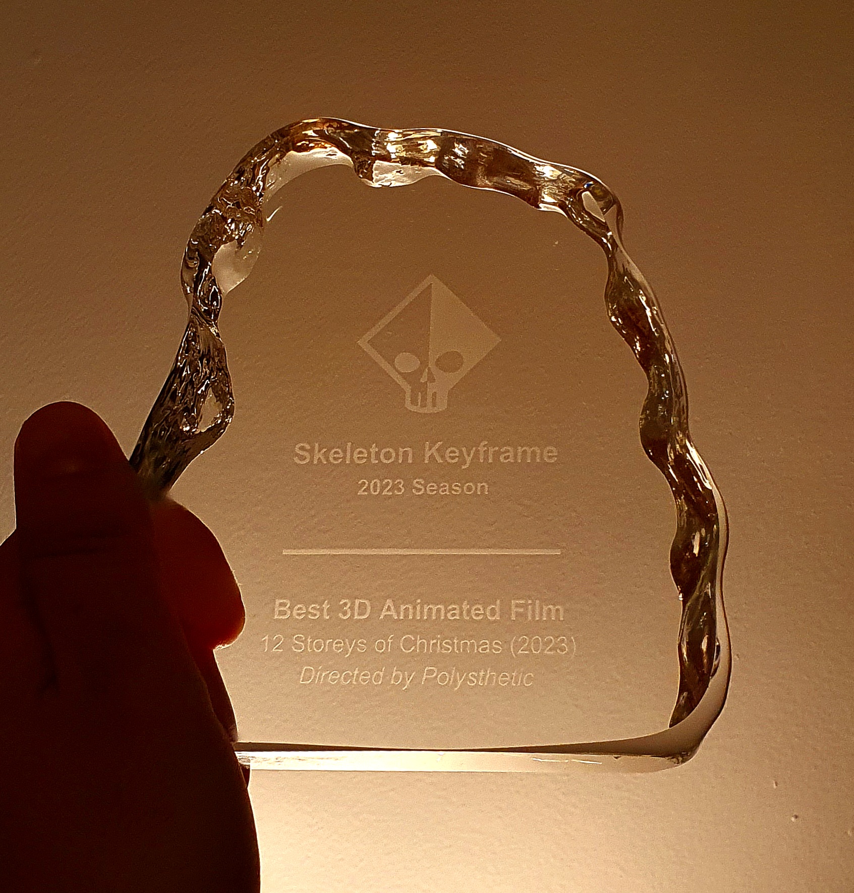 Solid glass award that reads Skeleton Keyframe 2023 Season Best 3D Animated Film 12 Storeys of Christmas Directed by Polysthetic.